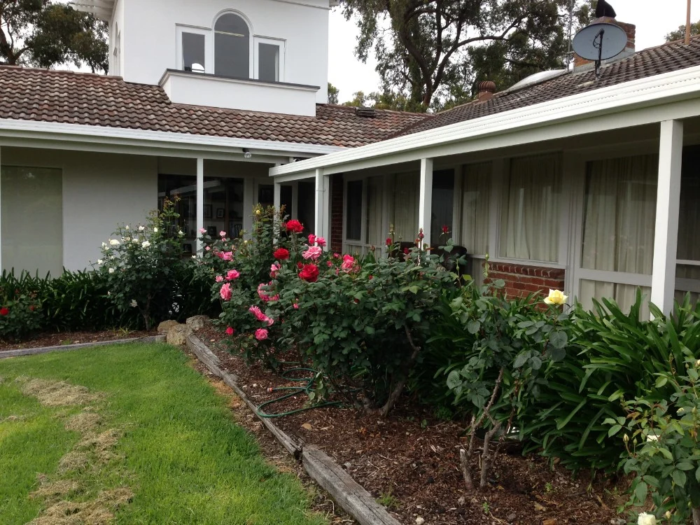 Period homestead with a verandah and rose garden