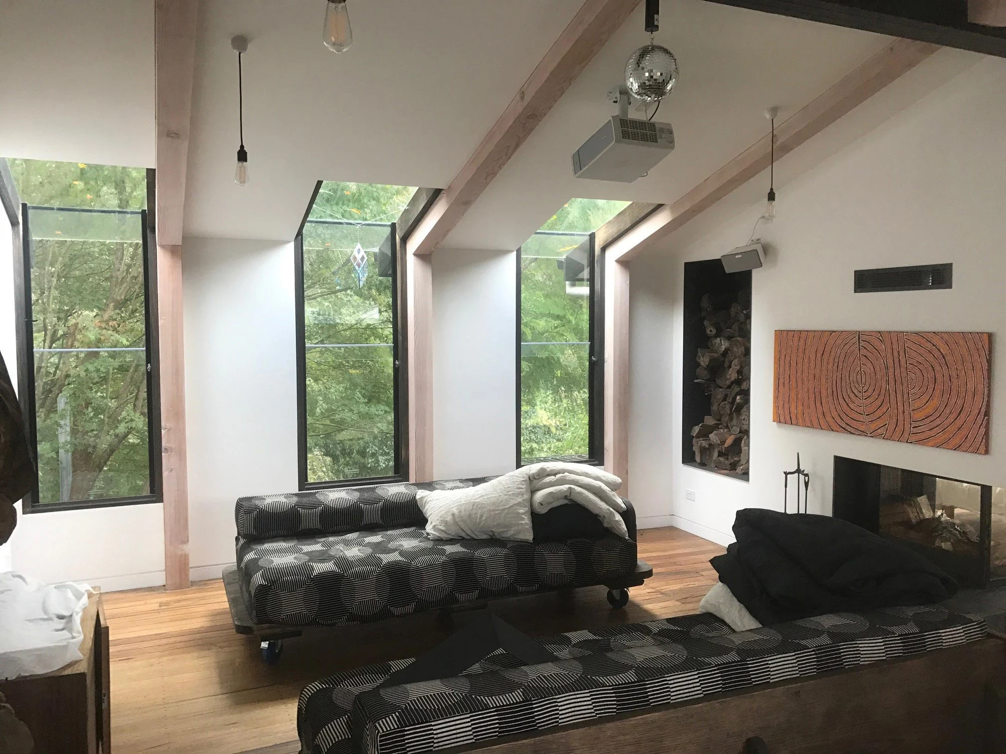 Living room with white walls, black exposed beams and a raked ceiling