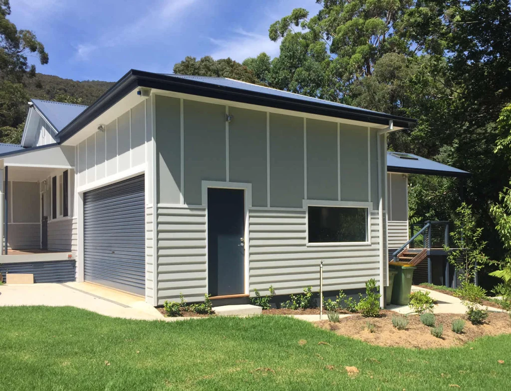 Grey weatherboard home with a freshly painted garage and trims