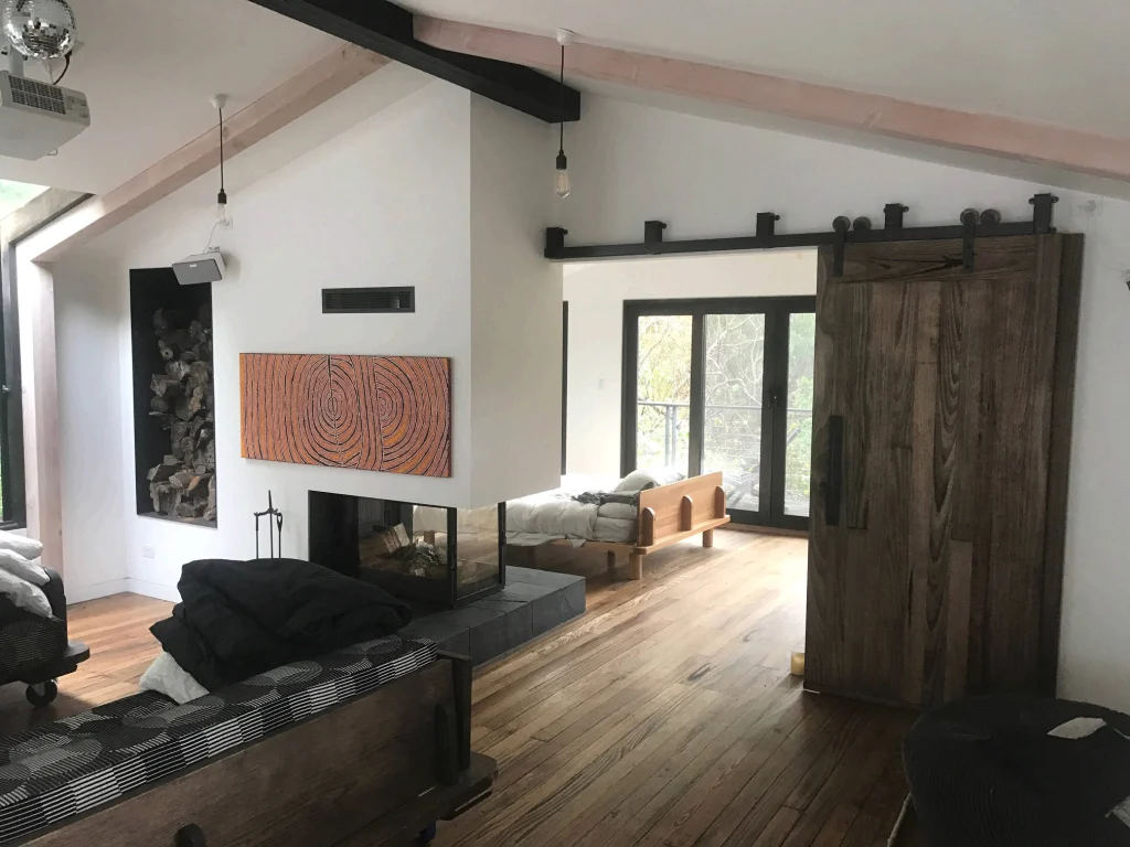 Open-plan living area with white walls and a timber barn door
